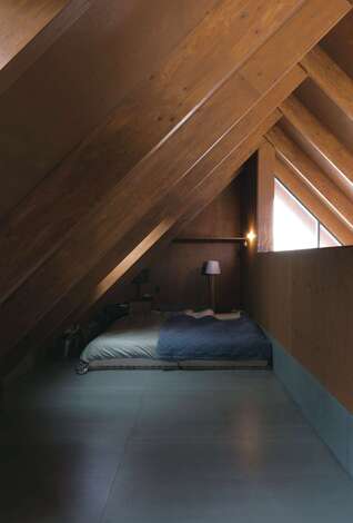 2階は大きなロフトのようなワンフロアのつくり。一角に配置した寝室は、リビングの気配を感じられて、屋根裏の程よいおこもり感も確保