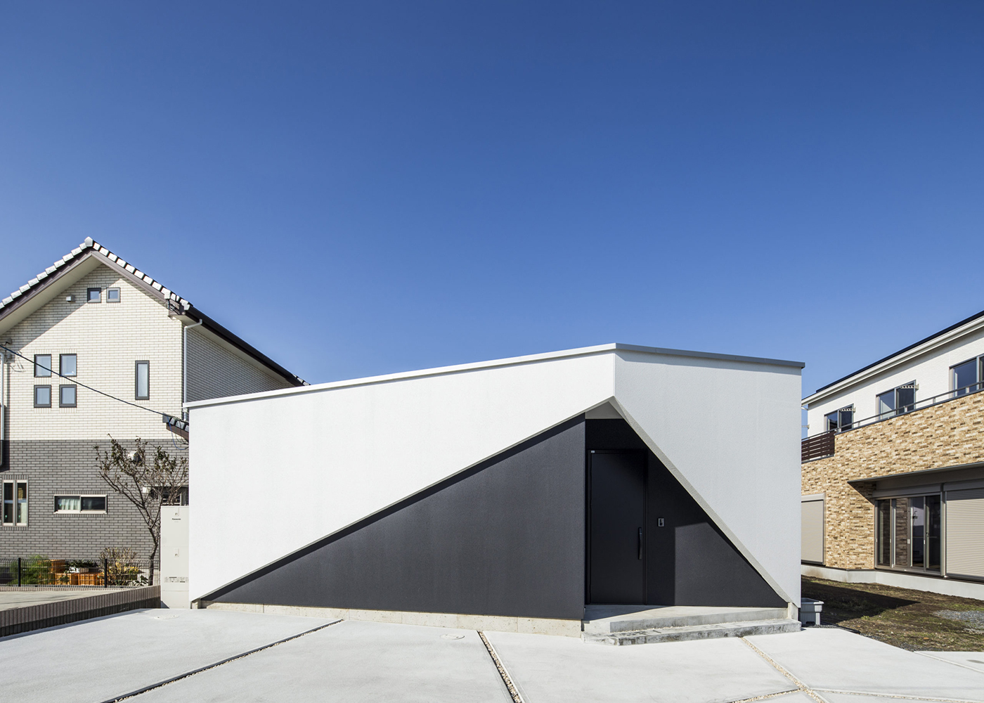 SIMPLE NOTE 豊川スタジオ【夫婦で暮らす、間取り、平屋】窓が一つもない、シンプルを極めた外観デザイン。グレー×白のクールな配色、鋭角に切り取った玄関ポーチがスタイリッシュでカッコいい