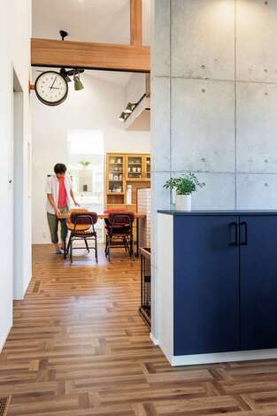 LDKとオープンに繋がる玄関。ブルーの収納扉やステーションクロックがアクセント
