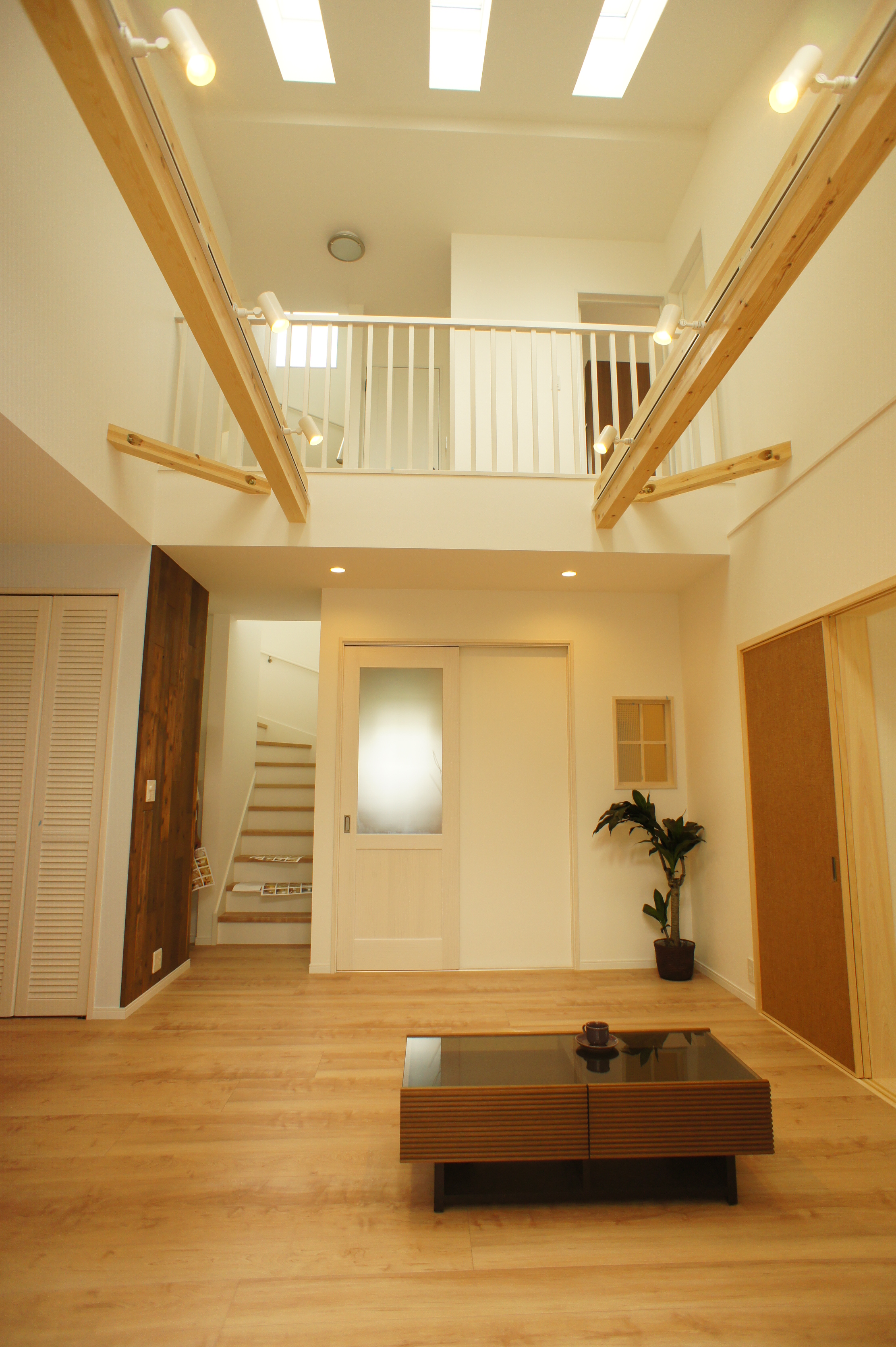 小野田産業～designers house project～｜吹き抜けのある明るいLDK。開放感あふれる空間で、天井からの自然光が心地よく差し込む。シンプルでスタイリッシュなデザインが特徴的である。