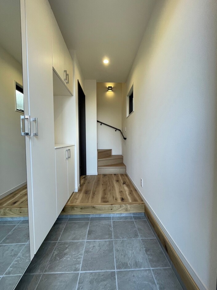 明るく広々とした玄関ホール。壁面収納があり、スッキリとした空間が保たれている。階段へのアクセスもスムーズで、機能的なデザイン。