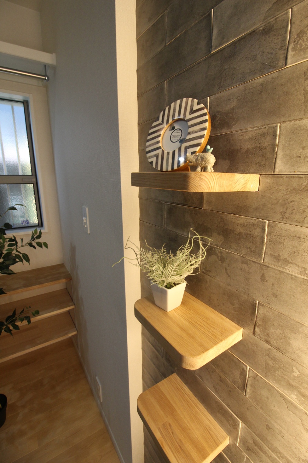小野田産業～designers house project～｜玄関ホールにはナチュラルな木製の棚が配置され、アクセントとして使われている。光で上品な空間を創り上げた。
