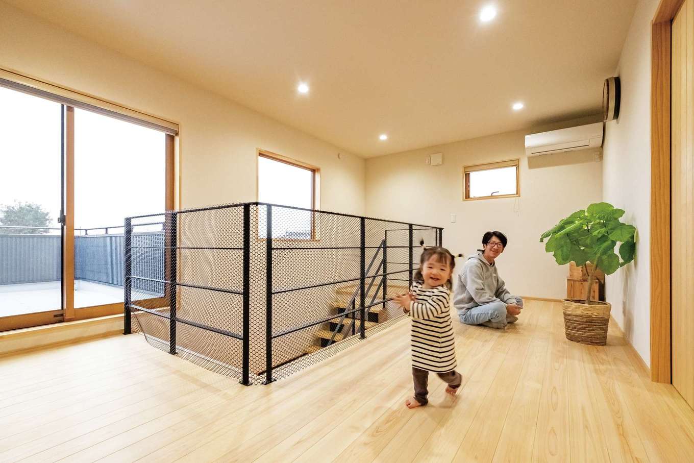 ワイズホーム【子育て、自然素材、省エネ】2階は、当初プランにあった一部屋を減らして、ホールを広くした。南西向きの窓から日中の光が差し込み、吹き抜けを通して階下に明るさを届ける