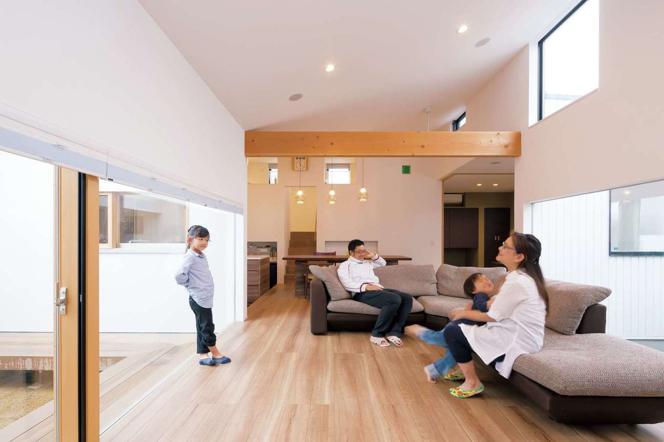MABUCHI【デザイン住宅、建築家、ガレージ】2つの中庭をのぞむLDK。隣家からの視線
を遮りつつ、自由に暮らせるよう、窓の高さ
を150cmに。夜になると、勾配天井の高窓
に美しい月が浮かんで見える