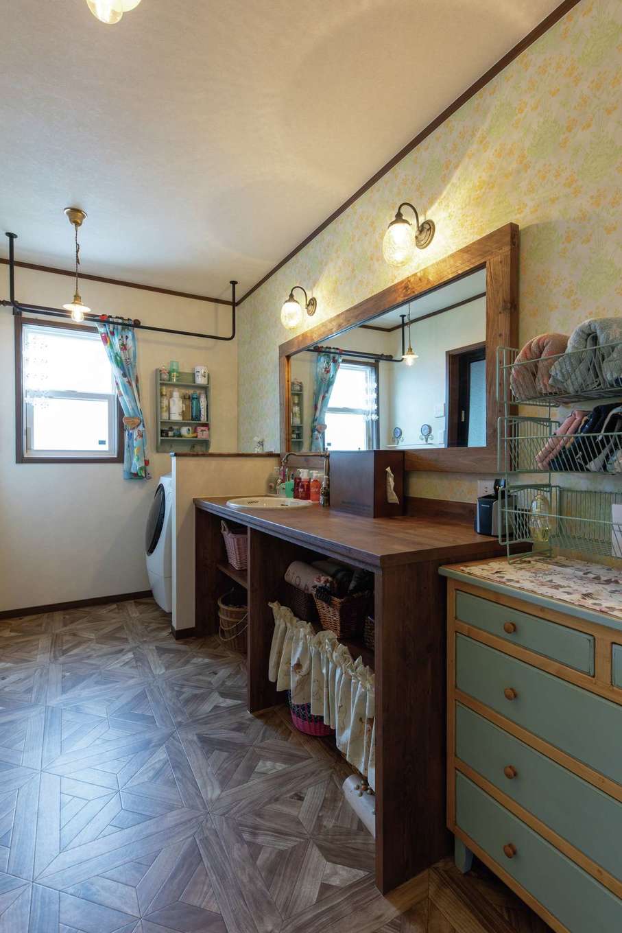 ハートホーム【デザイン住宅、自然素材、平屋】キッチンのバックヤードにしつらえた洗面脱衣室。ゆったりとしたスペースをとり、朝の混雑も解消。洗面台とワイドな鏡は造作で、おしゃれな空間にぴったり合う照明器具や真鍮の水栓金具は『ハートホーム』で購入した