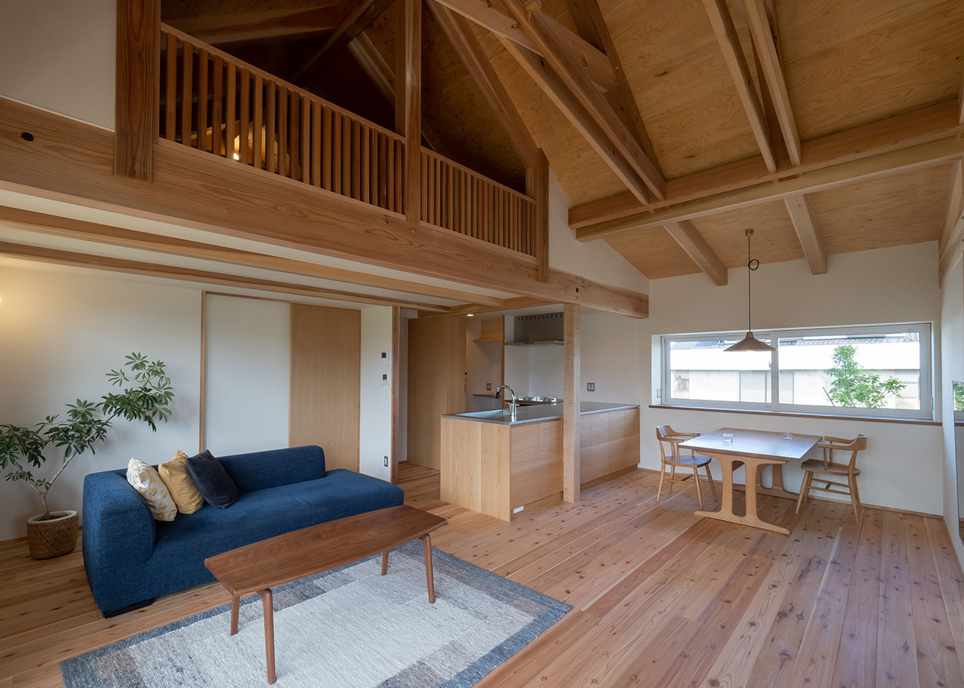 石牧建築【デザイン住宅、子育て、平屋】平屋でありながら、登り梁の現し天井が高さと開放感を感じさせるLDK。天竜杉の床をはじめ、梁やロフトの格子がアクセントになった天井は、時とともに色や雰囲気を変えながら、味わいを深めていく