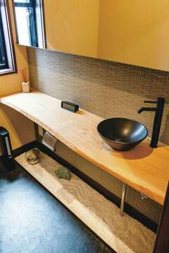 トイレにはセンの一枚板を使ったカウンター。石や砂利を敷いて、奥さまの好きな和の空間を演出