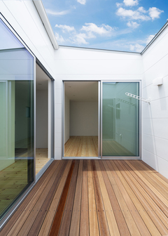 中庭のウッドデッキは、家の中から青空が見える贅沢な空間。外からの視線がカットされているため、BBQやプールも存分に楽しむことができる。洗濯物を干すのにも安心だ