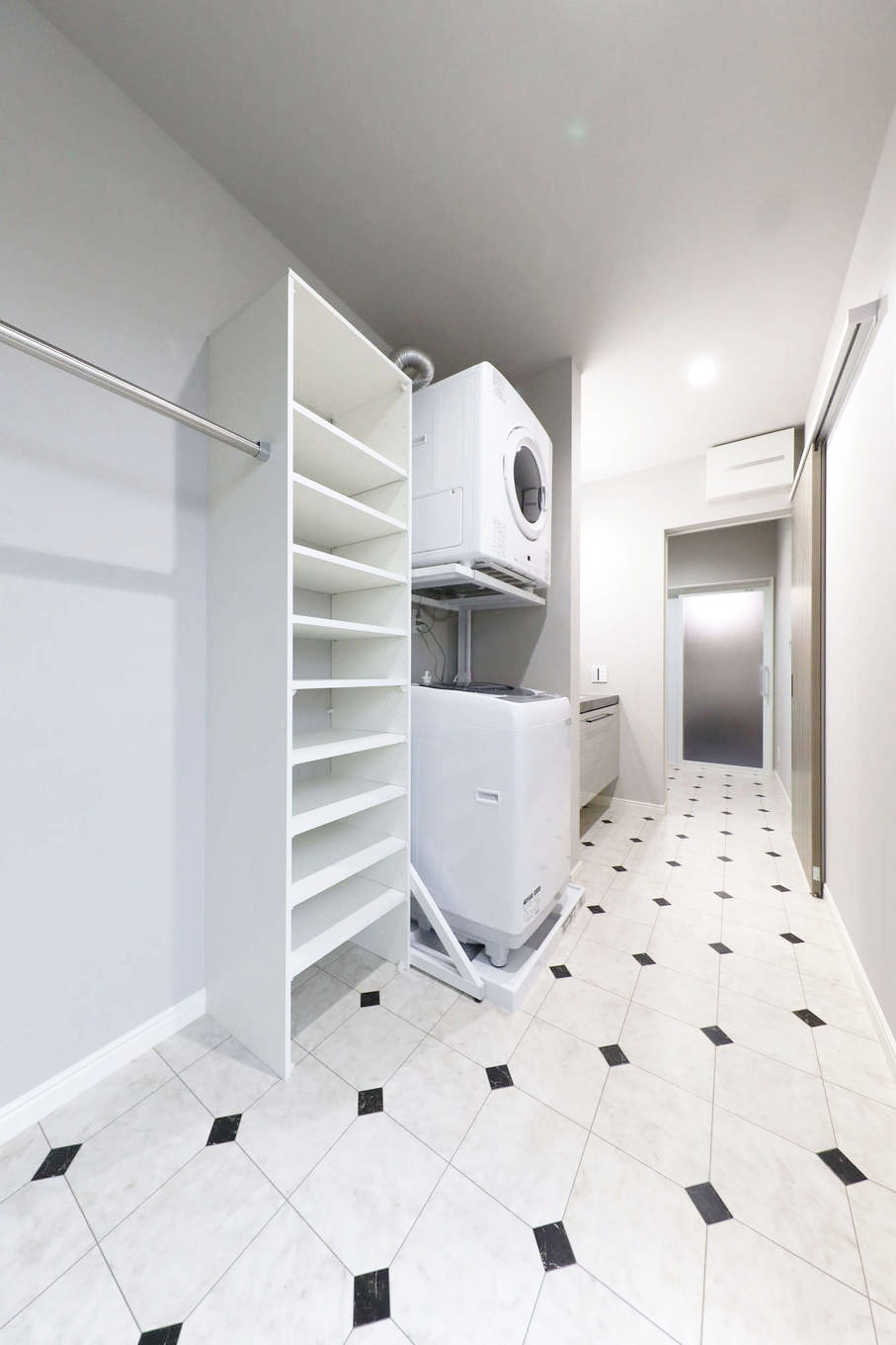 トーリンホーム【デザイン住宅、高級住宅、インテリア】２階にある住居のランドリースペース。洗面・脱衣・浴室と一列に繋がり、バルコニーにも出入りできるので洗濯の動線が抜群に便利。ランドリーには室内干しと収納スペースも確保