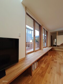 大きな窓から自然光がたっぷりと差し込むオーク材のカウンターベンチ。その下は本棚として使われる。