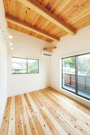 勾配天井を活かして、より広く感じられる主寝室。家族全員の布団を一度に干せるよう、バルコニーも広めに確保