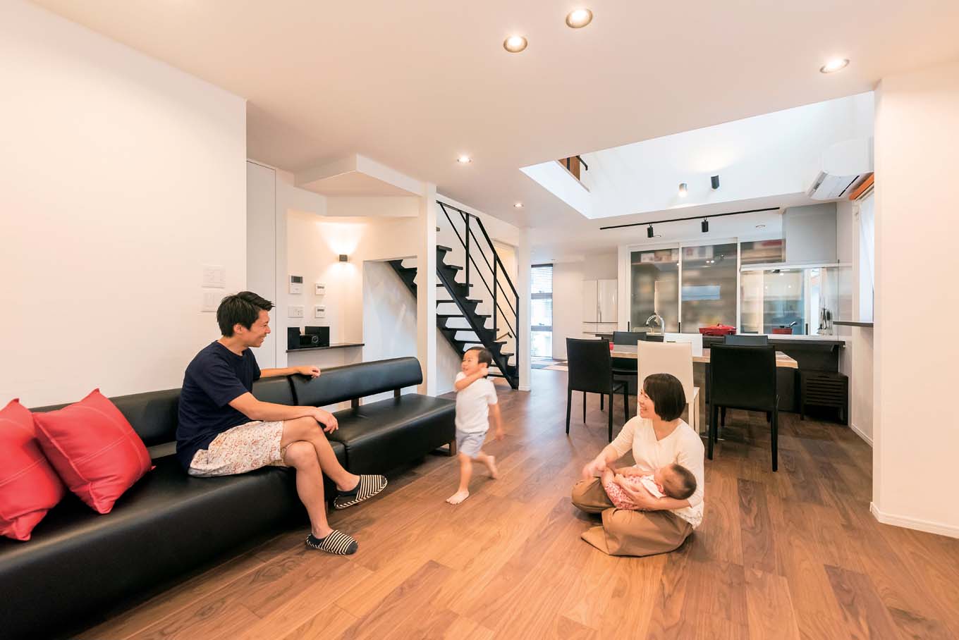 アトリエサクラ【デザイン住宅、間取り、ガレージ】休日は料理を作るというご主人が、ショールームで一目惚れしたキッチンからデザインを発想した2階のLDK。キッチン背面の大きな引き戸で隠れる収納に。ダイニング上部は吹き抜けにして3階と繋ぐ