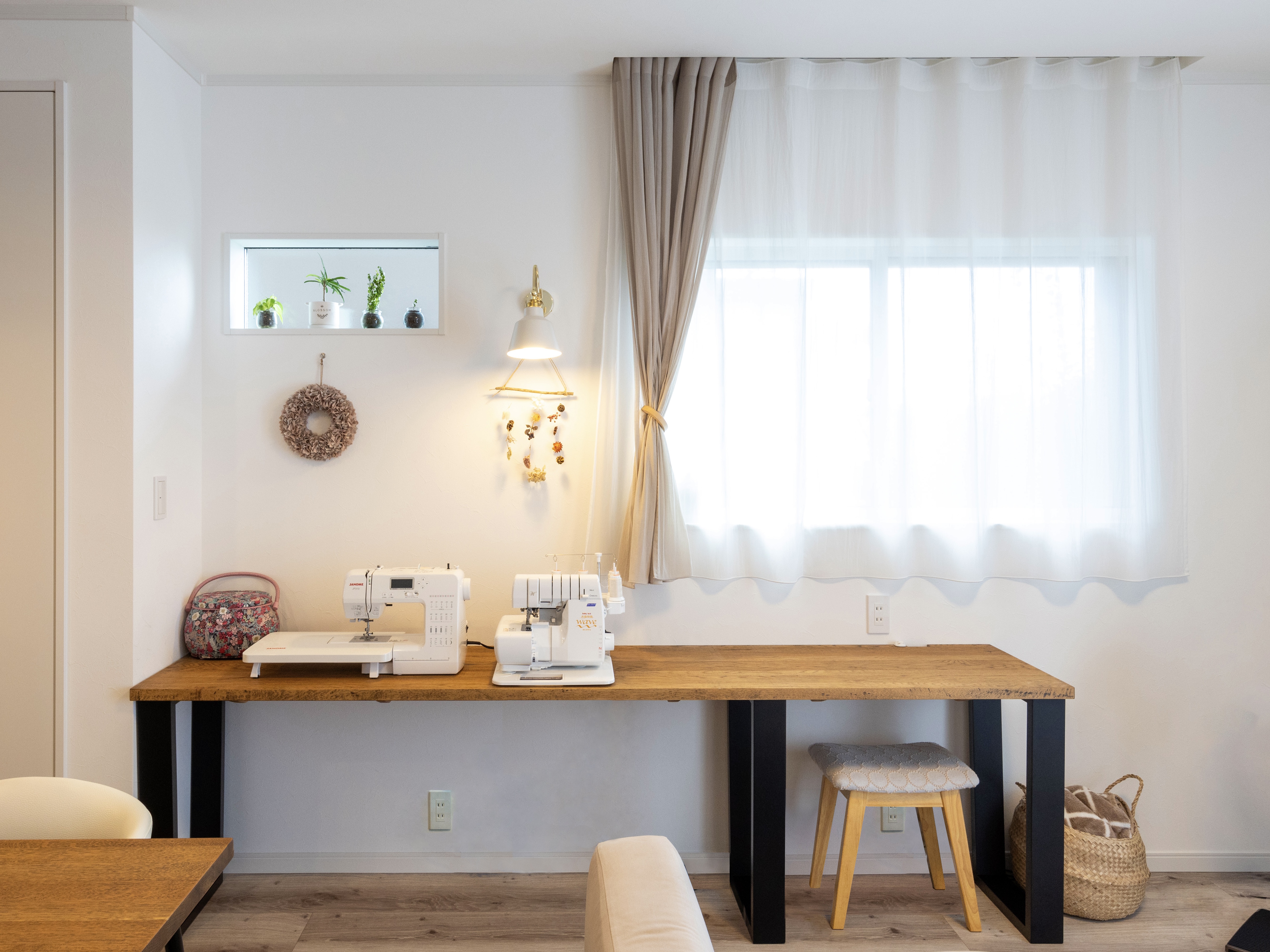 エスホーム｜大きな机が特徴の明るいワークスペース。自然光が降り注ぐ窓辺で、作業がはかどるデザインである。隣には植物が飾られ、リラックスした雰囲気を演出している。