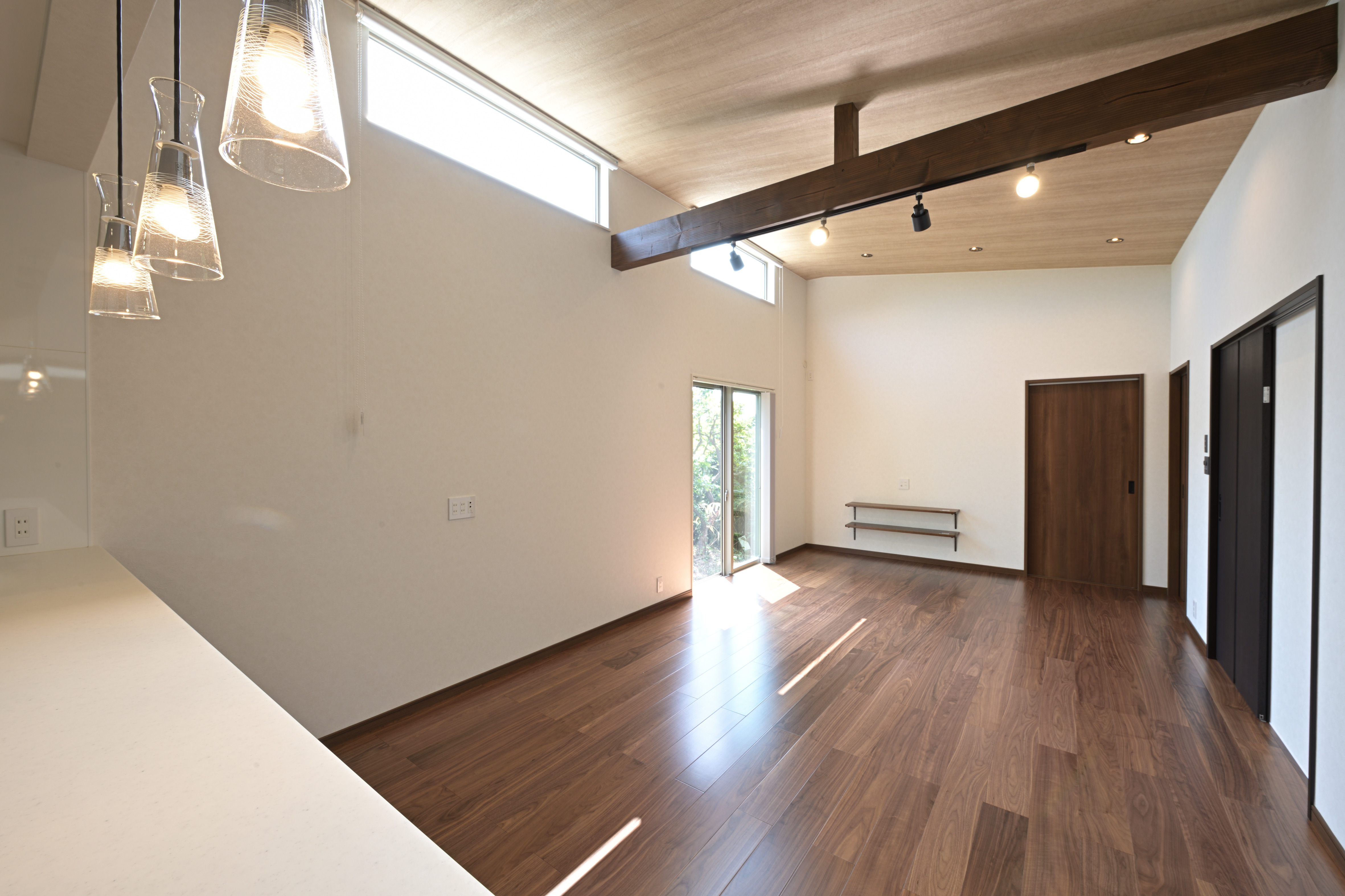 芳賀建工【子育て、収納力、間取り】勾配天井でより広く感じられるリビング。現しの構造梁がナチュラルな空間のアクセントに