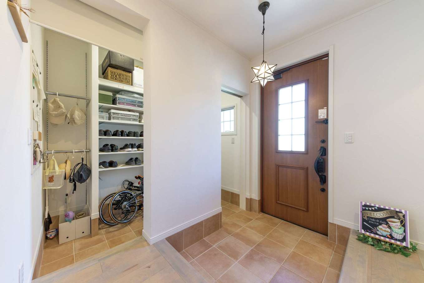 ハートホーム【デザイン住宅、自然素材、間取り】広い玄関収納のおかげで靴が散らからずすっきり。帽子やバッグをかけておけるパイプも付けた