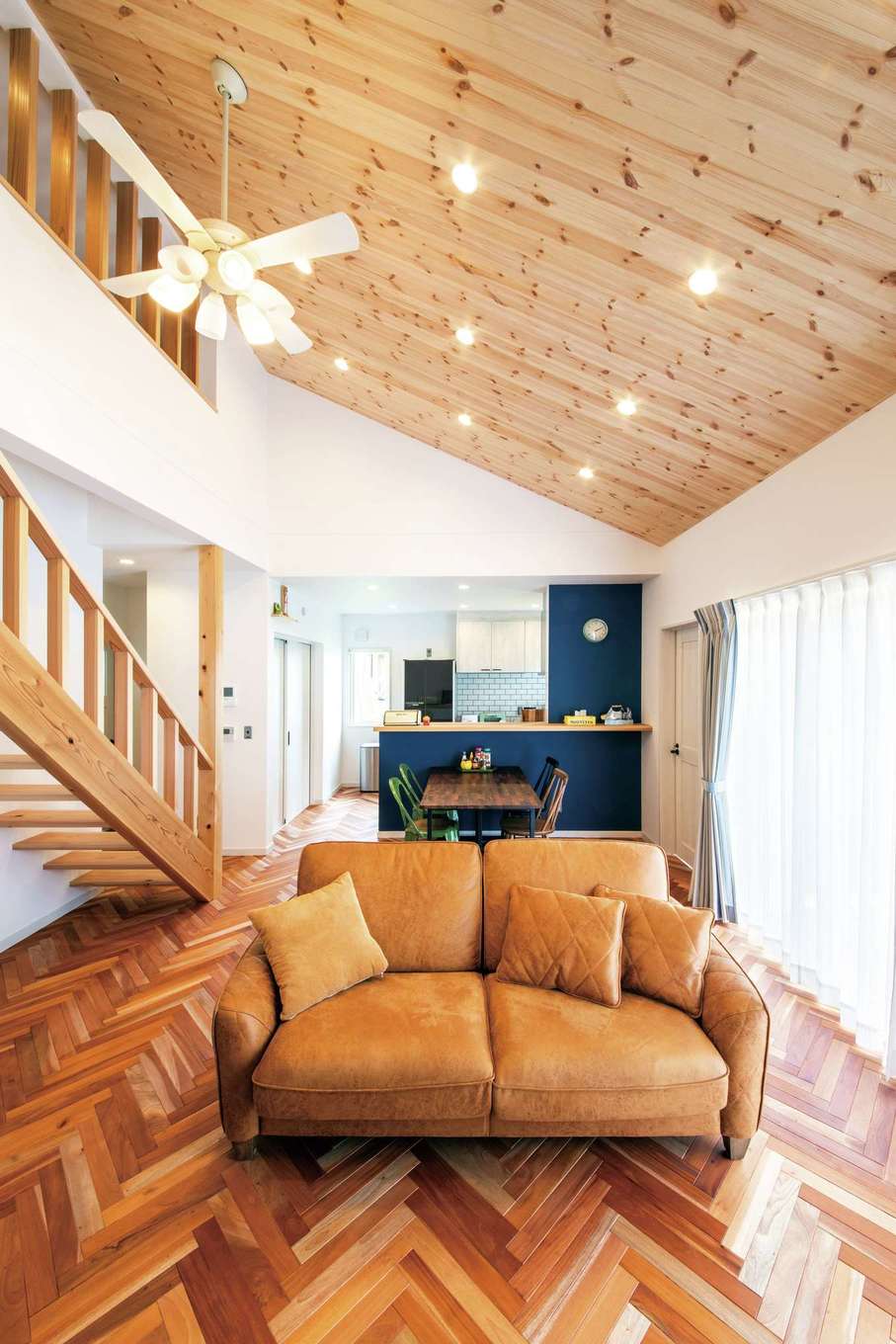 水田建設【デザイン住宅、省エネ、平屋】勾配天井がLDKとロフトを繋ぐLDK。ヘリンボーンの床や無垢のストリップ階段から、大工職人の緻密で確かな技術がうかがえる