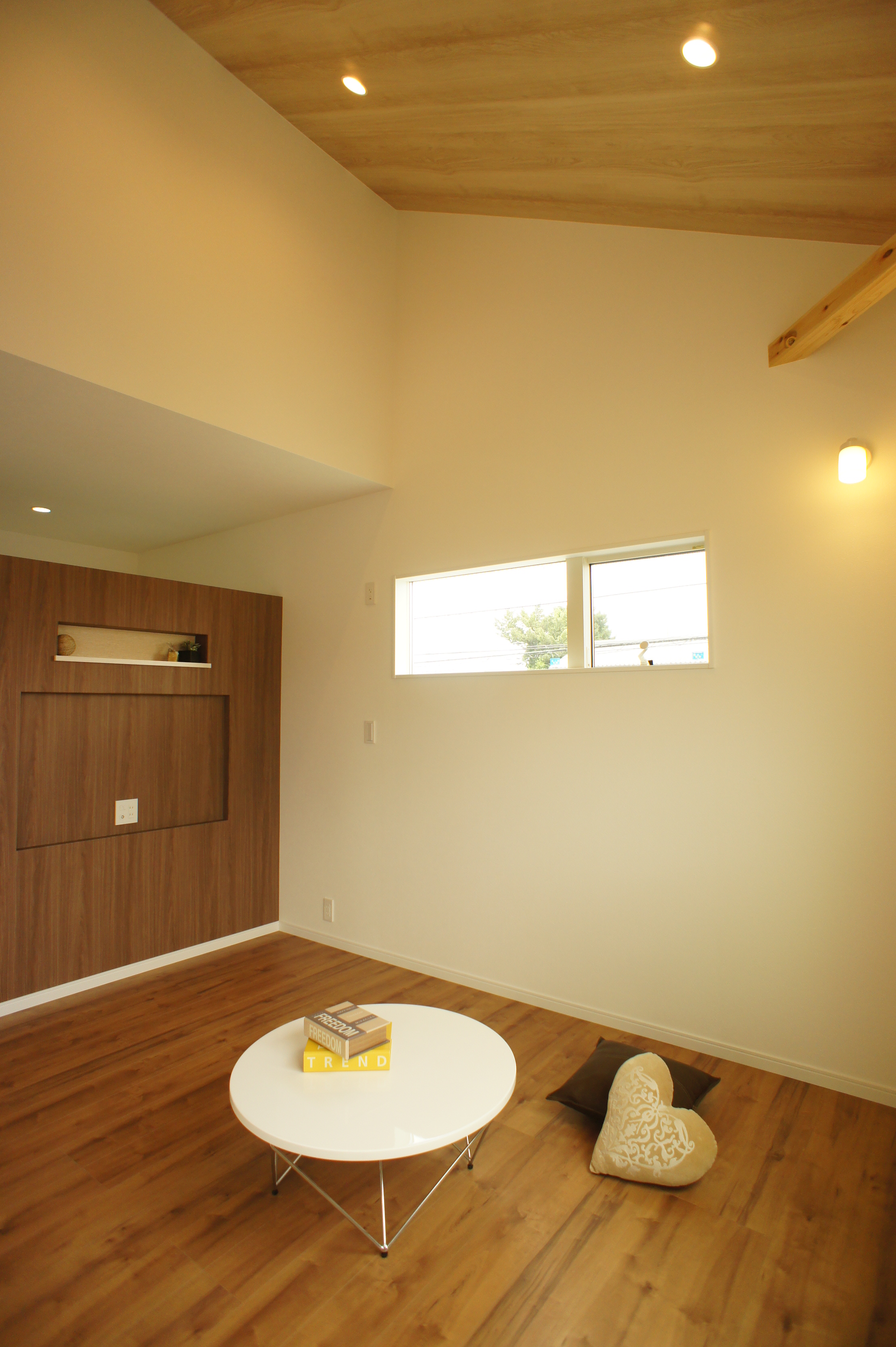 小野田産業～designers house project～｜高い天井と木目調のフローリングが魅力的な小屋裏収納。柔らかい光が差し込む窓があり、心地よい雰囲気を演出している。シンプルなデザインが落ち着きを感じさせる空間である。