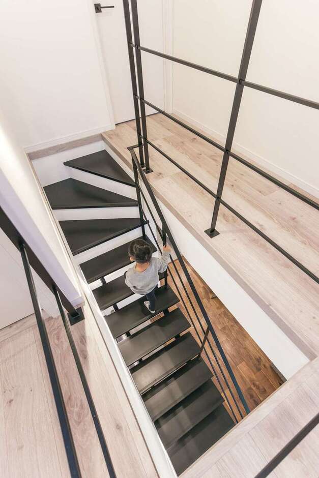 視線が抜けて開放感を増すスケルトンの鉄骨階段。繊細なスチールの手すりも白い空間に映える