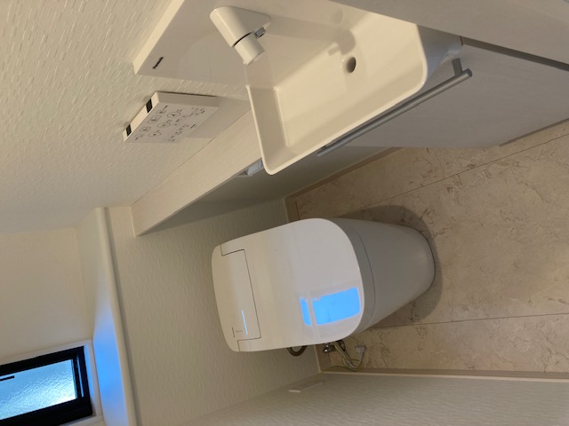 タムラ建築設計｜コンパクトで機能的なトイレ空間。シンプルなデザインで清潔感があり、使いやすさが考慮されている。手洗い器も設置されている。