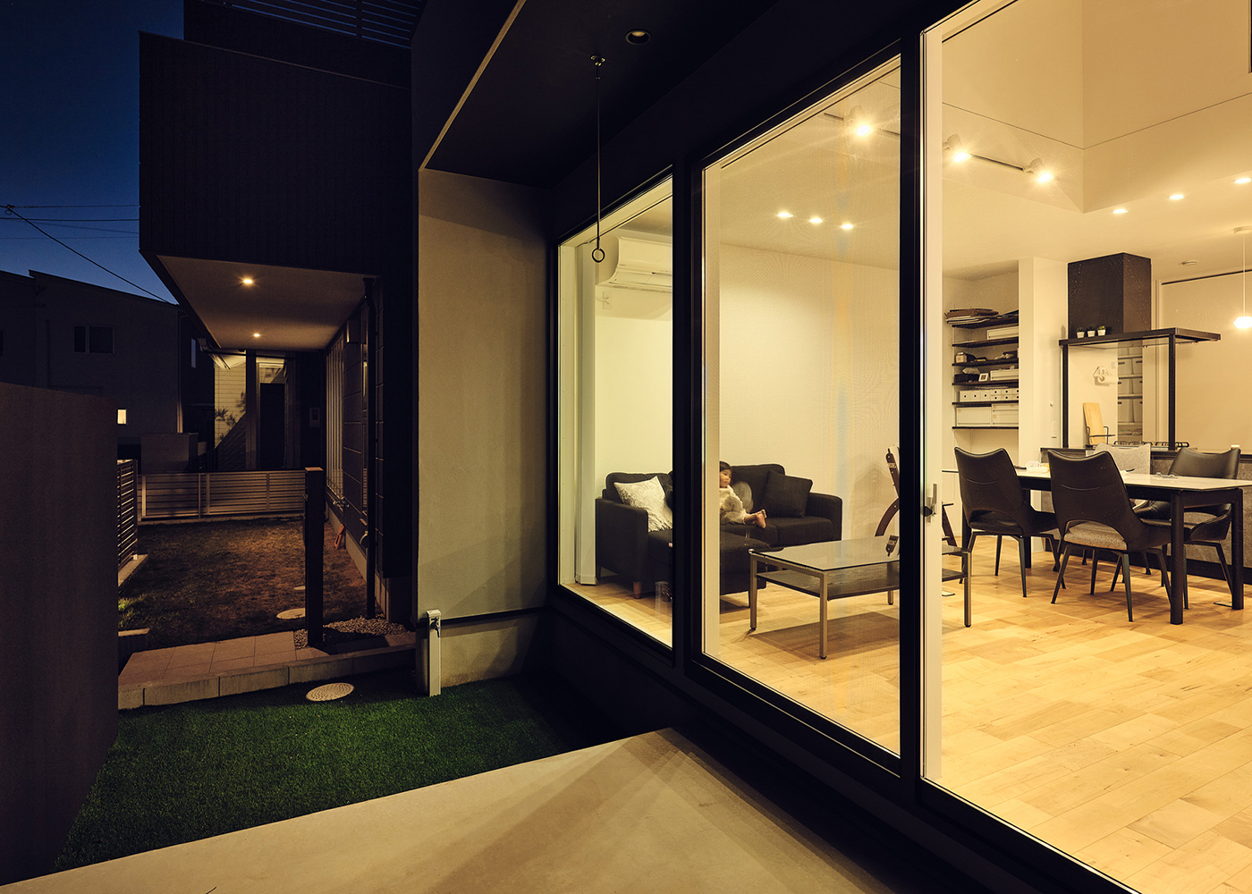 平屋建築ブルーハウス【デザイン住宅、間取り、ペット】夜のリビング。目隠し壁のおかげでカーテンいらず