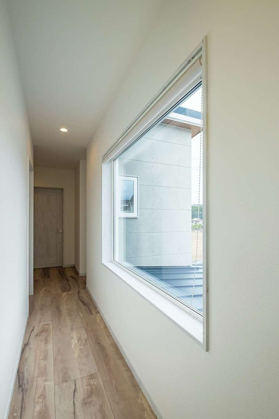 ぽっくハウス【リプルス】【デザイン住宅、狭小住宅、間取り】2階廊下に設けられた大きな窓はたっぷりの明るさを招きつつ、雄大な富士の姿を映す。外観のアクセントにもなっている