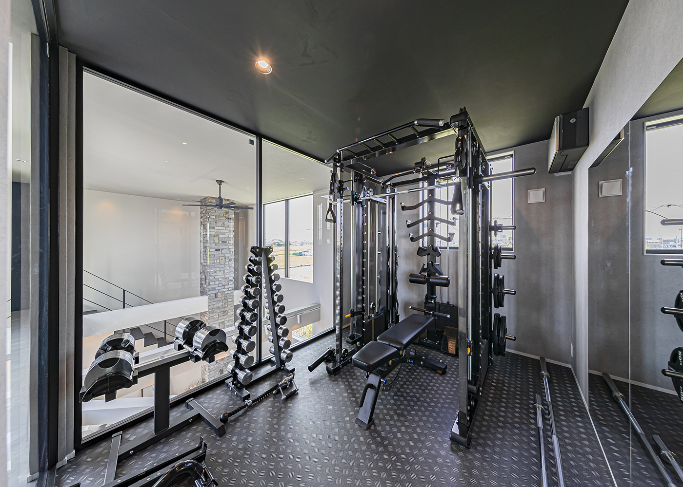 ARRCH アーチ【デザイン住宅、高級住宅、建築家】ご主人のトレーニングルームは、ジムに引けを取らないほど設備が充実。ガラス張りの窓からLDKを眺められる