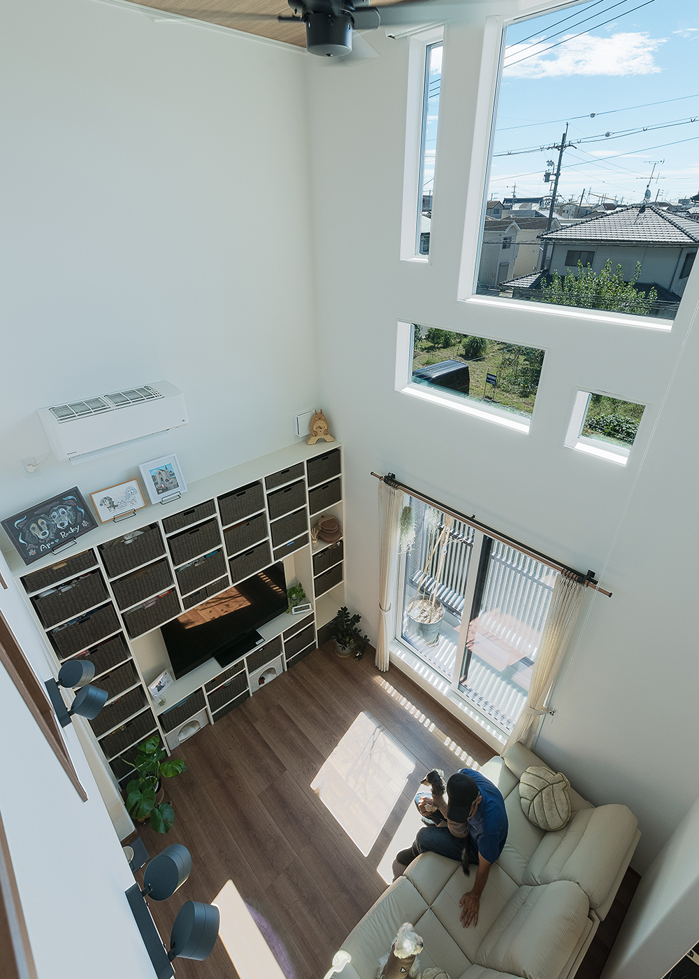 イシカワ【収納力、省エネ、ペット】ダイナミックな吹き抜けの大空間リビング。3階の特徴的な窓の形は奥さまがインスタで見つけてオーダーしたもの。これだけ大きな吹き抜けがあっても、同社ならではの高い断熱・気密・換気性能により、少ない冷暖房で快適に過ごすことができる