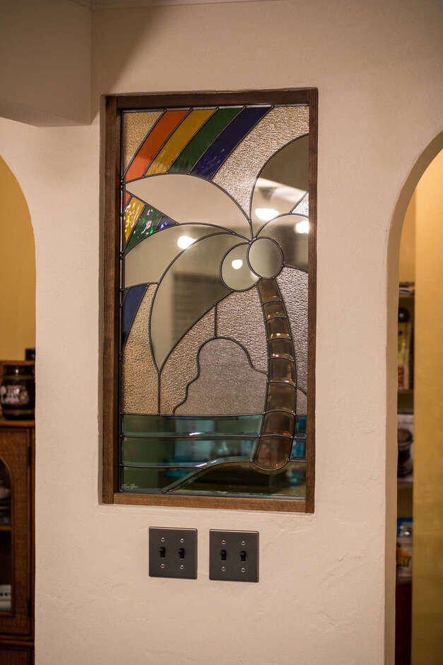 キッチンとパントリーを仕切る壁には、奥さまが一目惚れしたステンドグラスを埋め込んである。ヤシの実をモチーフにした図柄がハワイアン・ムードをいっそう盛り立てる