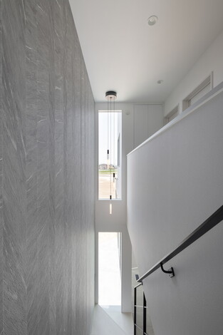 明るく開放感のある階段スペース。窓から差し込む自然光が心地よく、壁のデザインもモダンな印象を与える