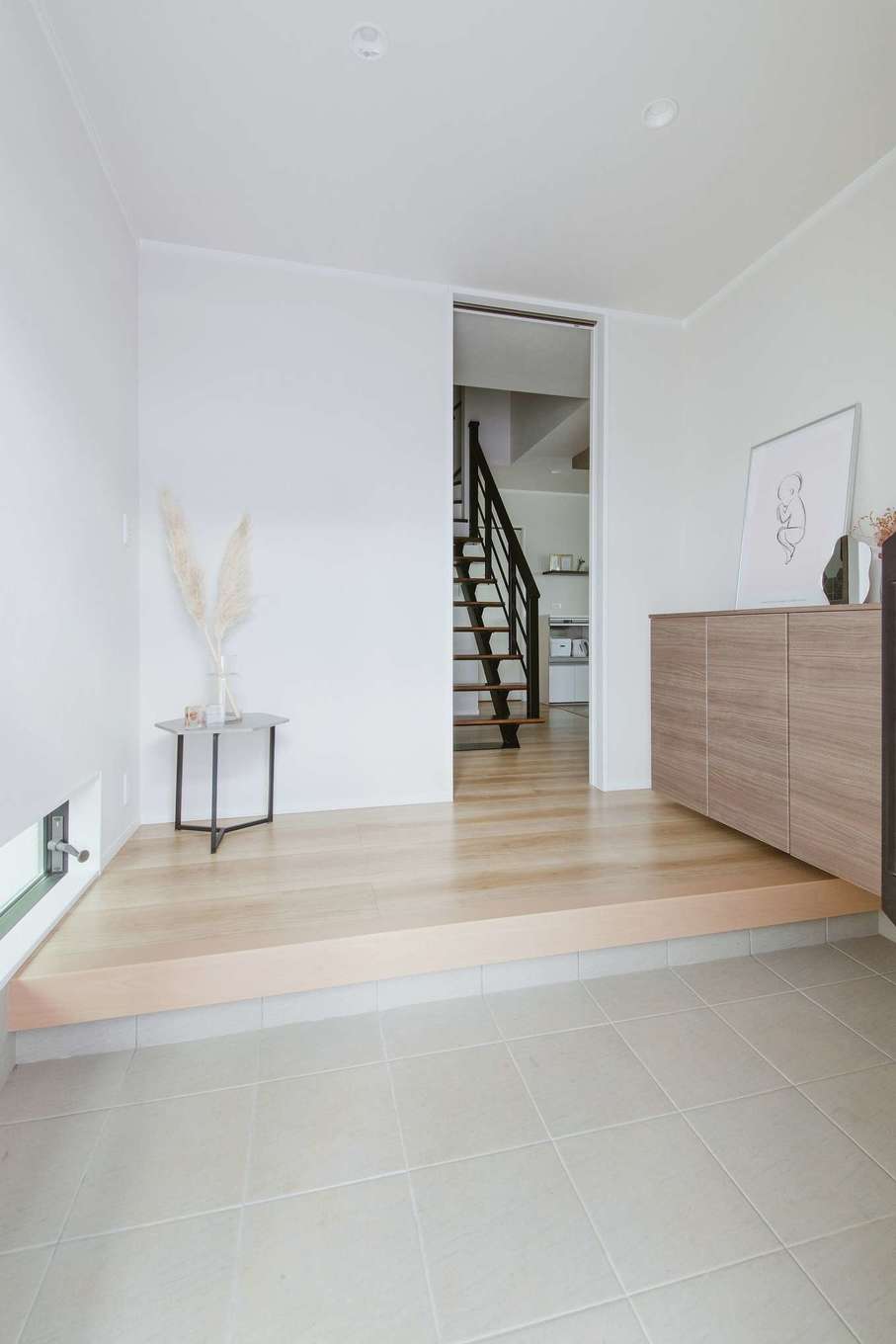 Yamaguchi Design 掛川店（アイフルホーム 掛川店）【デザイン住宅、子育て、間取り】引き戸の玄関ドアと地窓から明るさを採り入れた玄関。玄関ドアはキーレス仕様なので、子どもと荷物で両手がふさがっているときにも便利。ホールのすぐ奥にスケルトン階段を配置