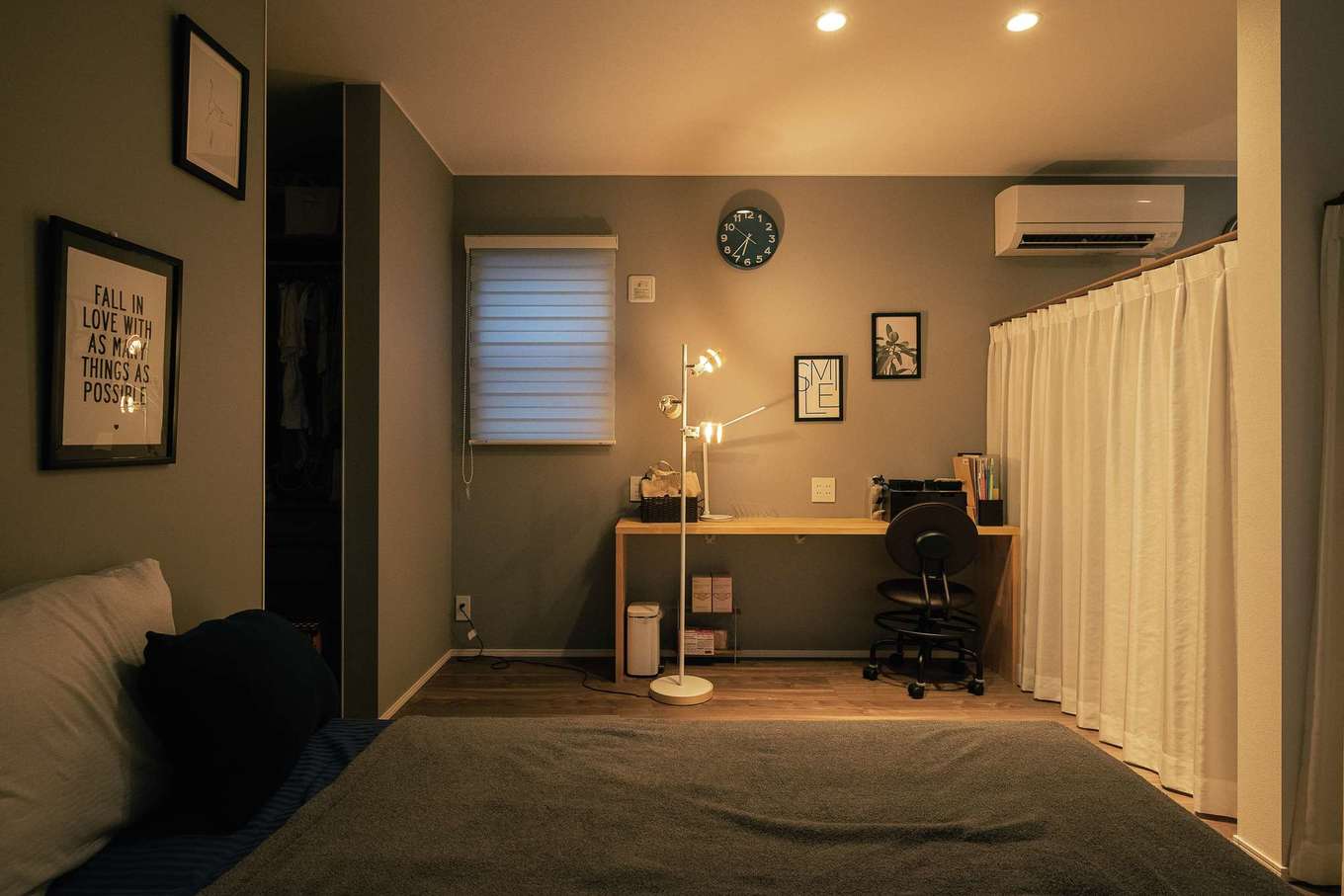 HAPPY HOUSE（山田工務店）【デザイン住宅、夫婦で暮らす、間取り】奥さまの部屋はご主人の部屋とひと続き。本棚で空間をやわらかく仕切り、それぞれの気配が感じられるようにしている。リモートワーク用にデスクを造作。全体のトーンはシックだが、左手のウォークインにはアクセントのクロスを採用した