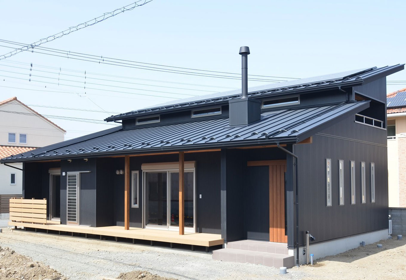 小澤工務店【自然素材、省エネ、平屋】大きく出した軒と薪ストーブの煙突が印象的。夏の日差しは大きく出た軒で遮りつつ、冬の日差しを家の中に招き入れる