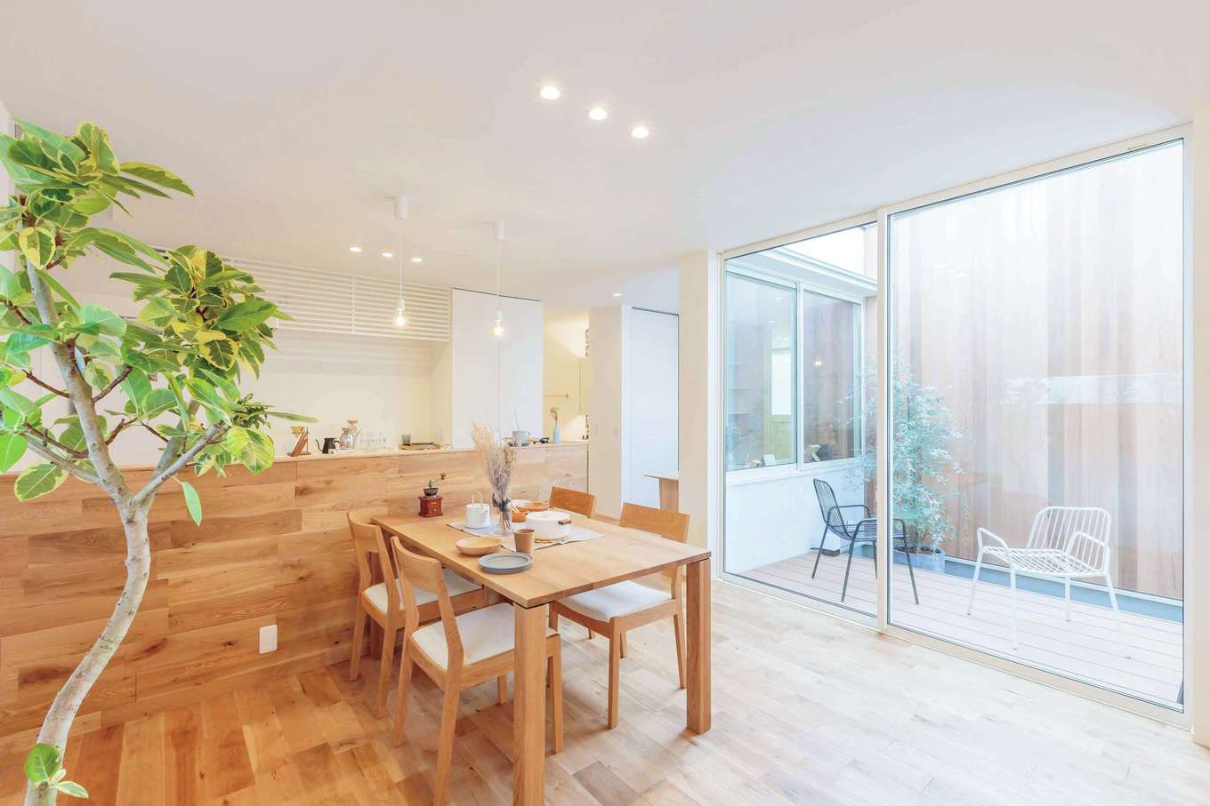 ARRCH アーチ【狭小住宅、建築家、平屋】ハイサッシの掃き出し窓を開けると、LDKとウッドデッキがフラットにつながる。中庭に面した窓にはカーテンが必要ないため、常に視線が空に抜け、吹き抜けのような解放感をもたらす