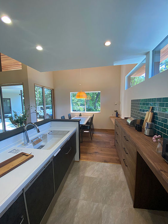 Techno Home Aizawa【デザイン住宅、自然素材、高級住宅】リビング天井にはマホガニー、床はウォールナットを採用。キッチンは下がり天井にして、空間にアクセントを。床はタイルでメンテンナンス性・耐久性を確保