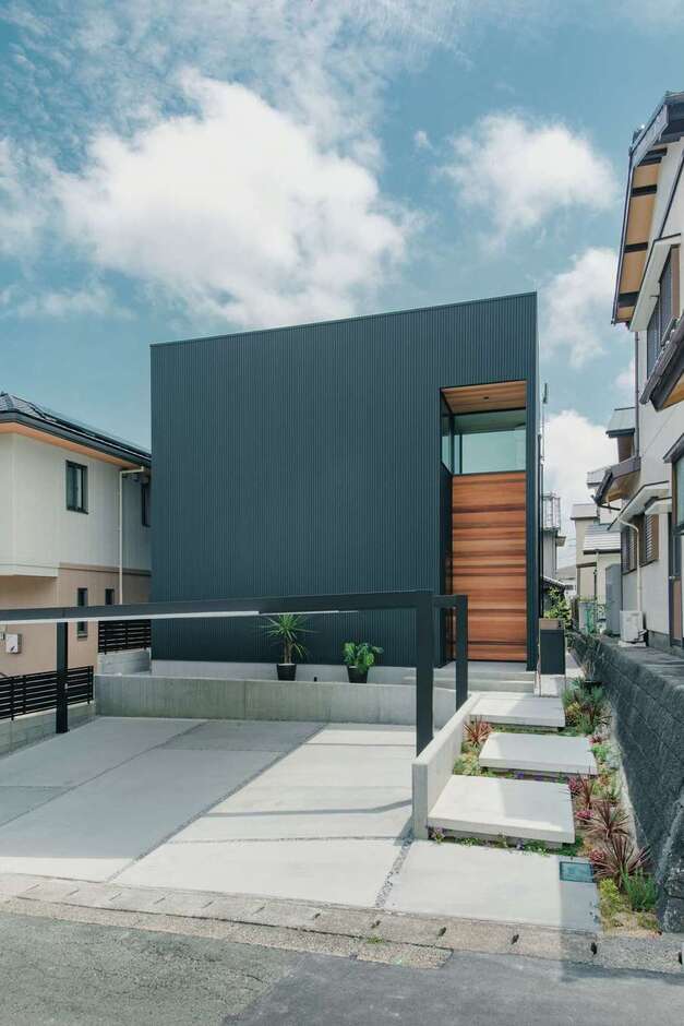 玄関ポーチにあしらったレッドシダーが印象的。外からの視線や防犯に配慮し、正面の窓は2階のみ。植栽が彩るステップ状のアプローチは夜になると間接照明が灯り、幻想的な雰囲気に