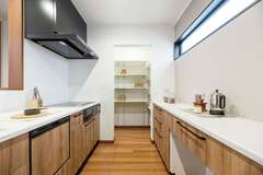 作業スペースを広くとったオープンキッチン。パントリーも十分な広さで、食品や生活雑貨を整理整頓でき、家事効率アップにも貢献