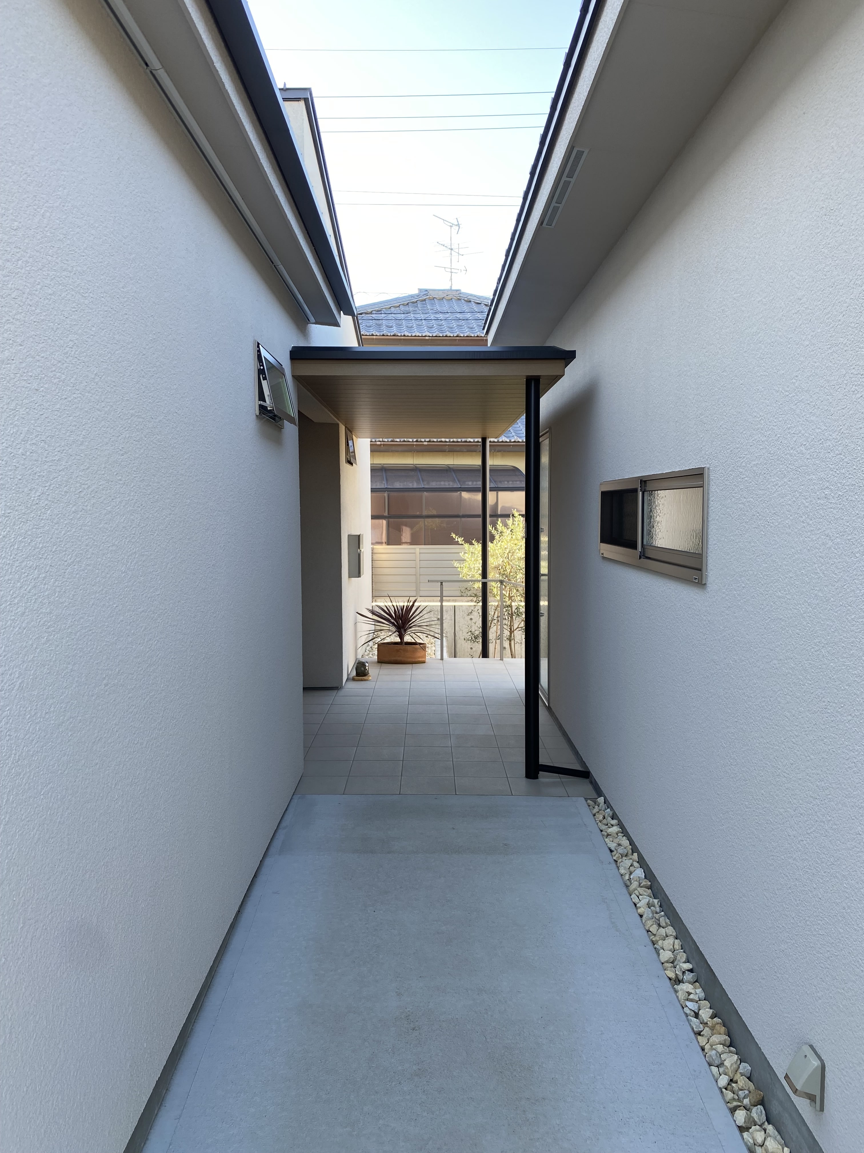 安田住宅｜安田建築設計室｜別棟をつなぐ通り土間、スロープとして機能している。奥行きを感じさせるシンプルなデザインと自然光が差し込むことで、明るく開放感のある空間を実現している。