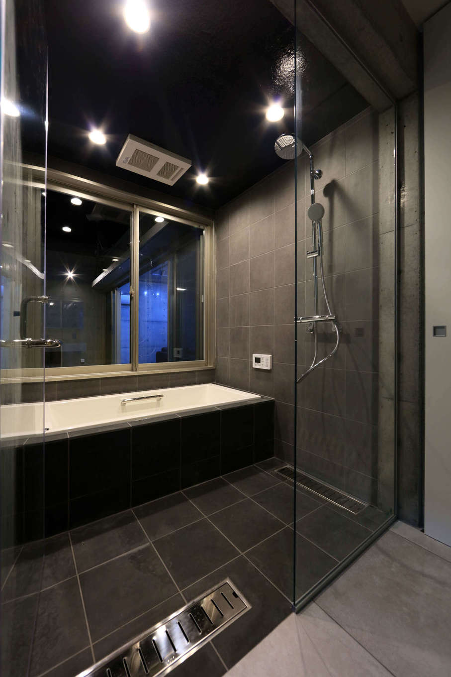 BAUM HOME（岩崎工務店）【デザイン住宅、平屋、鉄骨鉄筋コンクリート構造】フルオーダーの浴室は、ガラス扉を採⽤してホテルライクな空間に仕上げた。窓を中庭側に配置しているため、開放的な雰囲気の中でくつろげる