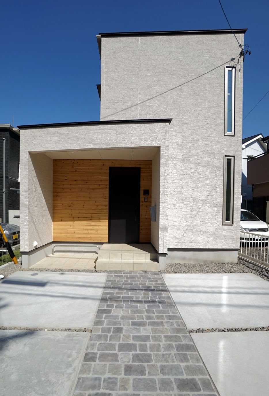 RIKYU 一級建築士事務所【デザイン住宅、間取り、建築家】建築家設計の住宅らしい独創的な外観デザイン。木目調のサイディングがアクセントに。ポーチに軒を設けたことで、雨の日もストレスフリー