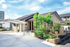 飽きのこないやさしい色合いの外観。外構の一部に旧家にあった石や塗り壁を再利用した
