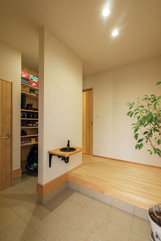 玄関は来客と家族の動線を分け、壁を程よい目隠しに。小さな手洗いを設置して、帰宅後の動線もスムーズ