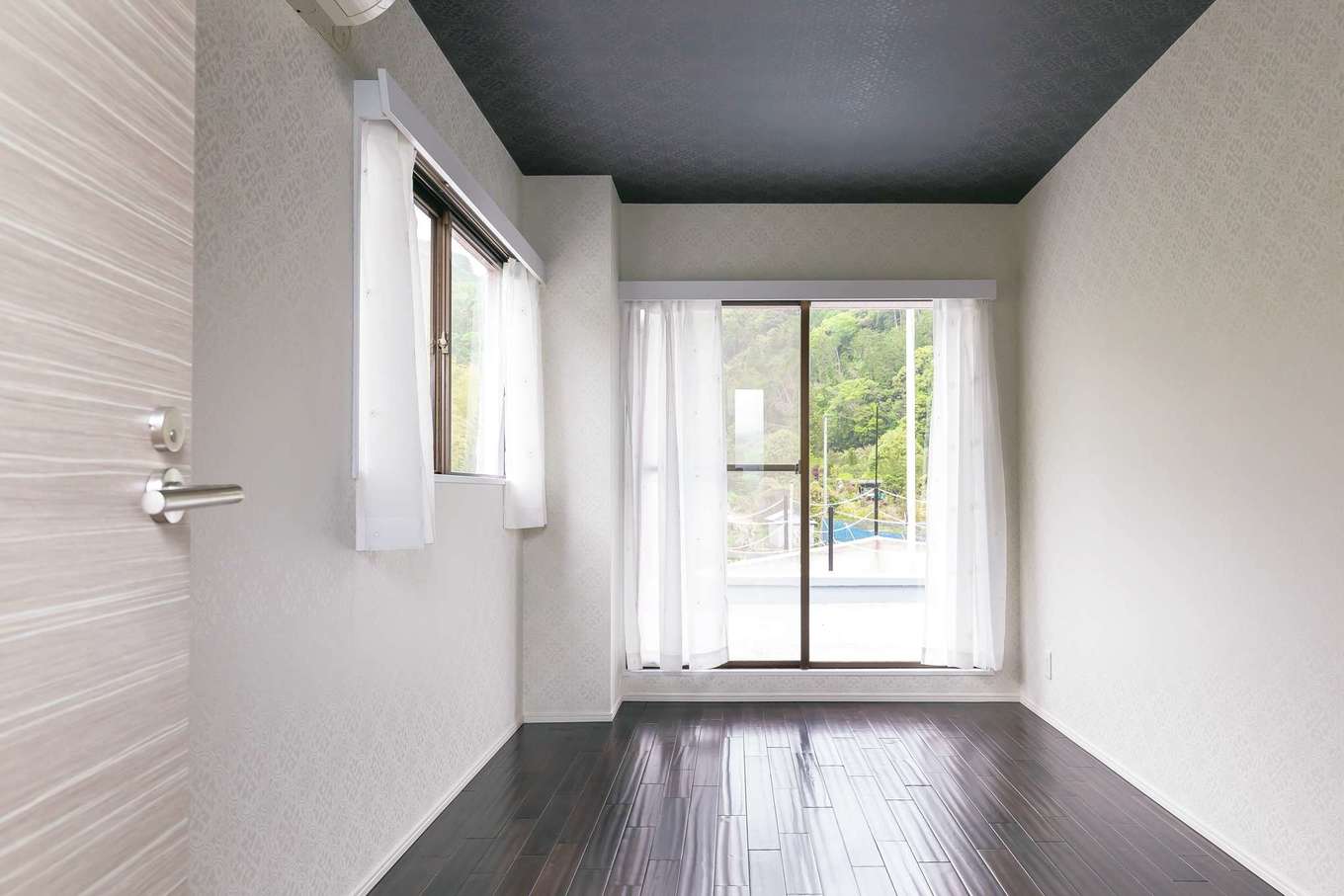 nattoku住宅｜主寝室の床は同じ無垢材を使い、アンティーク風の色に変えて。窓を開けると、船の舳先（テラス）へとつながる