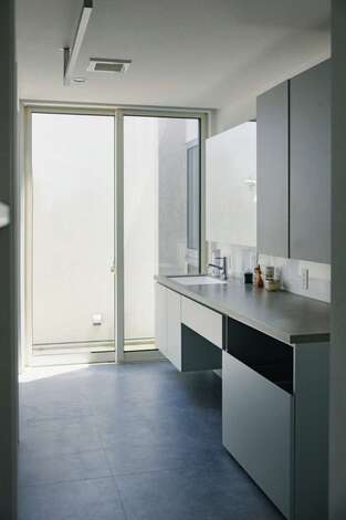 カッコよくて使いやすい造作の洗面化粧台。窓を開けるとオープンエアのテラスにつながり、外干しもできる