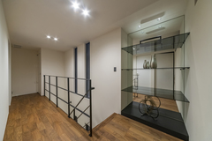 ２階ホールには広さを感じさせるために壁面にミラーを用いた棚を造作している。棚板はブラックガラス。細部のテクスチャーまで抜かりなくコーディネートされている