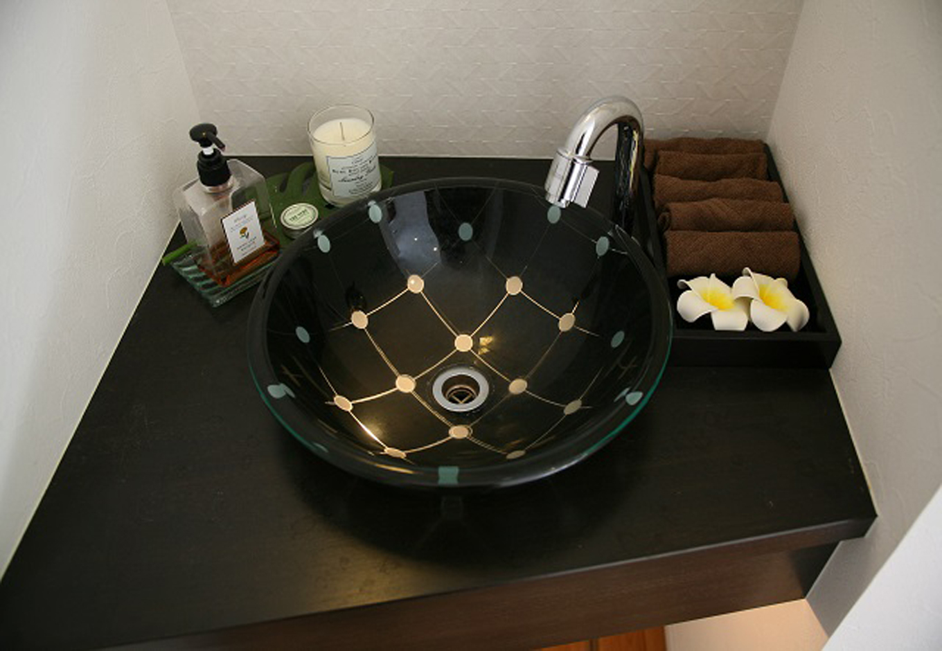 ソーラーホーム/OMソーラーの家【デザイン住宅、子育て、省エネ】手洗いのガラスボウルは、下から光を灯すことで独特の温もりを演出。毎日使うものだからこそ、「気分良く使えるものを」とこだわった