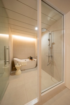 ガラスの仕切りでスッキリとした見た目のバスルーム。スタイリッシュなバスタブとシャワーが清潔感を演出している。