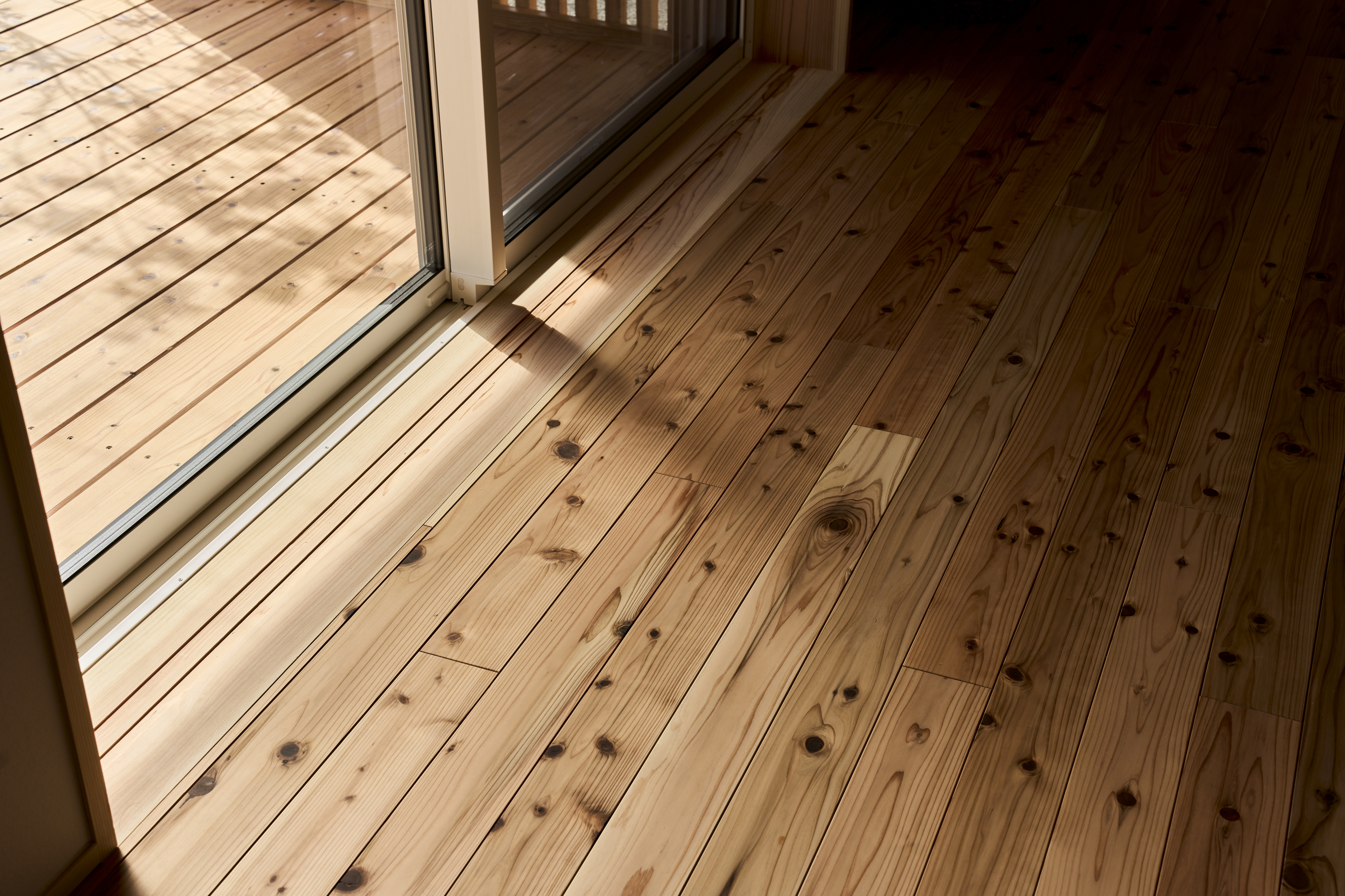 KEN建築工房｜無垢の床材を使用し、匂いも肌触りも心地よくなっている。
縁側のウッドデッキと一体感がある空間になっています。