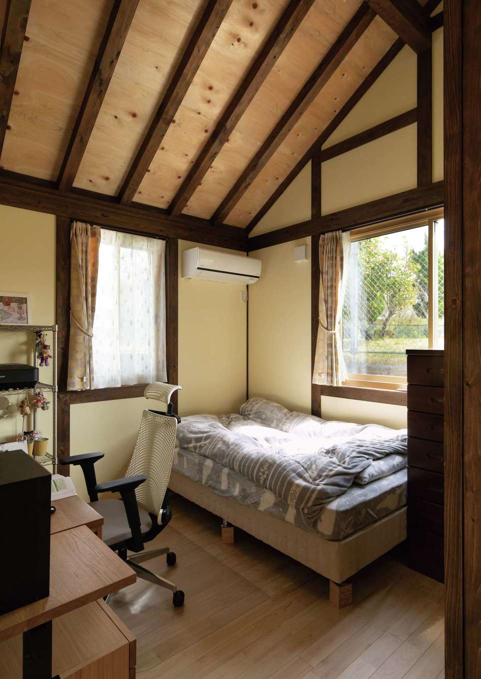 サイエンスホーム【趣味、自然素材、平屋】子どもの部屋も勾配天井で、実際の広さ以上の開放感に満たされる。周囲には緑も多く、プランニングには敷地の持ち味も反映。無垢ヒノキの床は家中に採用されている