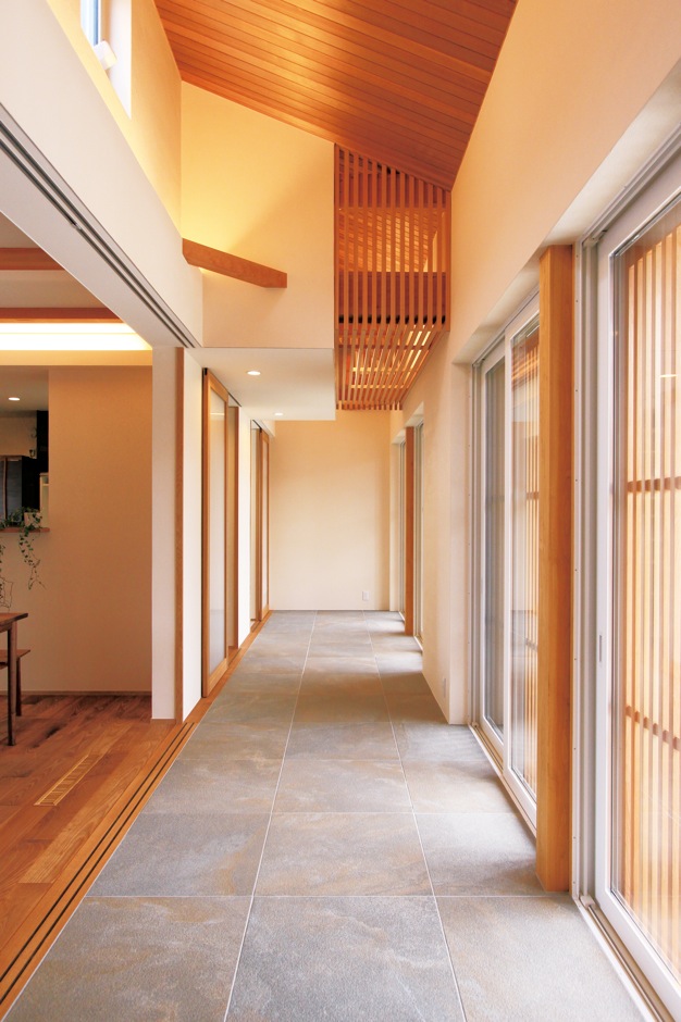 神谷綜合建設 カミヤの家【和風、省エネ、平屋】LDKの南面に配置された土間空間は、外と中をつなぐ中間領域。この緩衝帯が夏の直射日光を遮りながら空気の流れを生み、冬は太陽熱を吸収する蓄熱帯として、室内の温熱環境を調節する