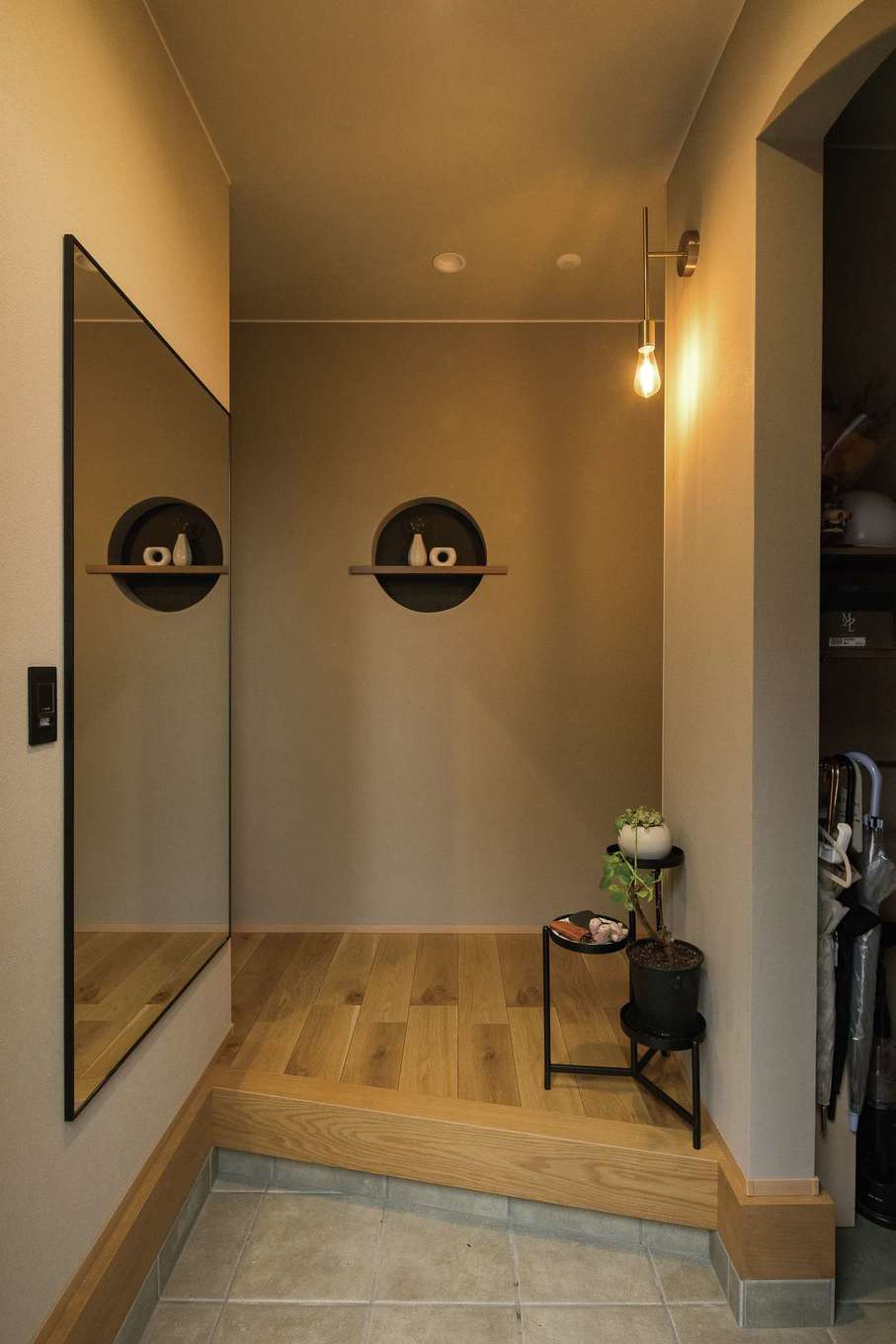 HAPPY HOUSE（山田工務店）【デザイン住宅、省エネ、インテリア】玄関は斜め框とし、視覚的な広さとオシャレさを演出する。正面の壁は塗り壁で、和を感じさせる丸型のニッチを依頼。右手のシューズクロークの入口もRに仕上げてもらった